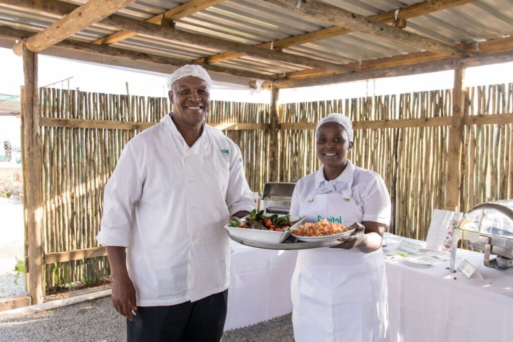 Chefs holding food for a function.